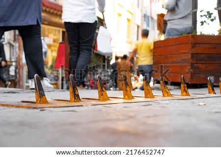 Close-up of yellow spikes for a tire puncture for stopping the car in a street of Istanbul Royalty-Free Stock Photo #2176452747