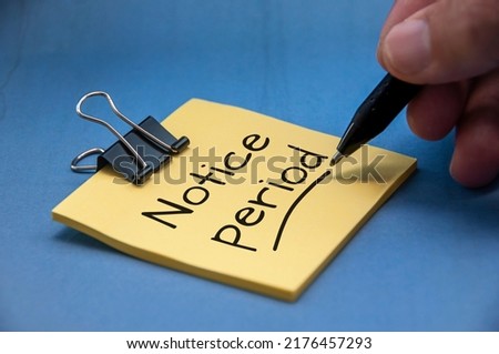 Notice period text on sticky note with hand on blue cover background. Resignation and business concept Royalty-Free Stock Photo #2176457293