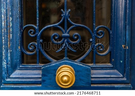 Fragment of an old blue door with a gold handle close-up.