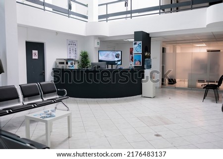 No people in waiting area for patients with doctor appointments in modern healthcare clinic in private practice hopital. Empty waiting room with front desk reception with promotional flyers. Royalty-Free Stock Photo #2176483137