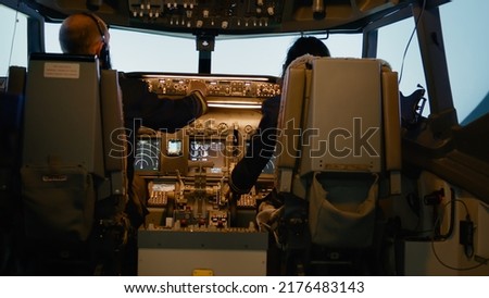 Captain and copilot inserting destination coordinates and fixing altitude and longitude level on dashboard command in cockpit. Using control panel to fly airplane and takeoff.