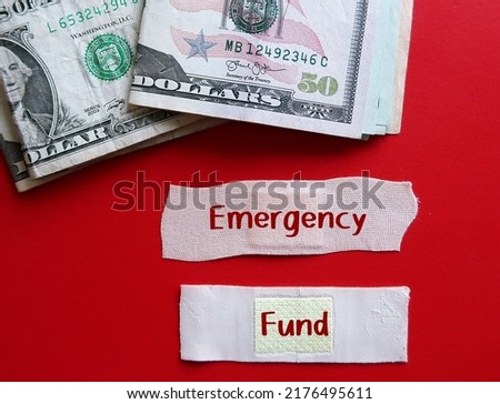 Cash dollar money on red background with plaster band aid written EMERGENCY FUND, concept of money set aside to pay for unexpected expenses, financial safety net for future problem Royalty-Free Stock Photo #2176495611