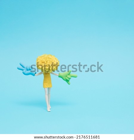 Doll with marigold head showing peace (victory) and ILY, I love you signs. Creative hand gesture concept.