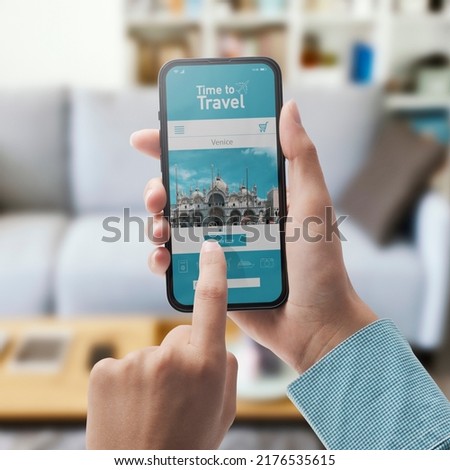User connecting with her smartphone at home and online travel booking app on the phone display, POV shot