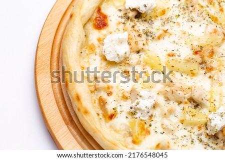 Delicious pizza with pineapple, chicken and ricotta cheese served on a wooden plate. Top view. Flat lay.