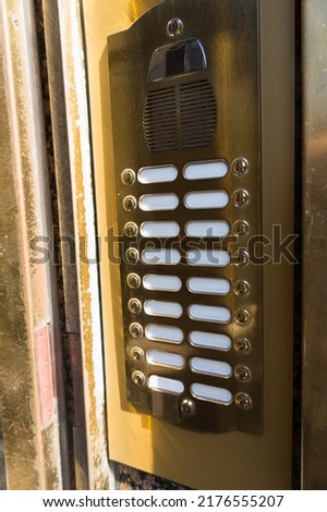 Noble high-quality retro vintage golden bell board door bells with several buttons next to nameplates in front of the entrance door to an apartment building in Vienna Austria