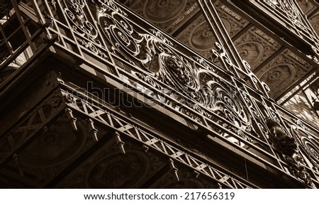 Beautiful balcony with forging railing. Architectural detail. Paris, France. A game of light and shadow. Aged photo. Sepia.