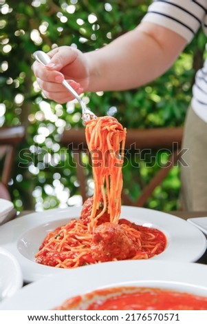 A view of a hand doing a noodle pull of spaghetti.