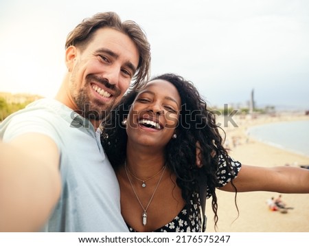 Personal perspective of a young heterosexual couple taking a selfie during a sunset on vacation. Honeymoon concept