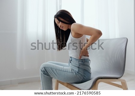 Suffering from scoliosis osteochondrosis after long study pretty young Asian woman feel hurt joint back pain laptop in incorrect posture sit on chair. Injuries Poor health Illness concept. Cool offer Royalty-Free Stock Photo #2176590585