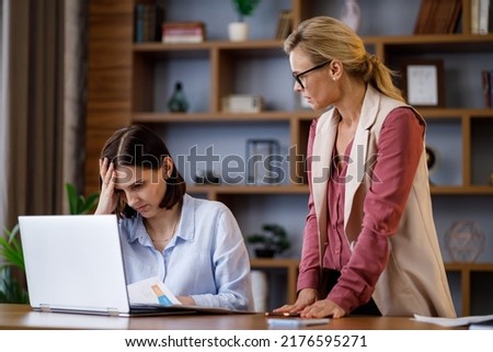 Angry female boss scolding scared office worker. Demanding manager leader is annoyed at laziness and mistakes in work of employee. Authoritarian leadership, abuse of power, malfeasance in office Royalty-Free Stock Photo #2176595271