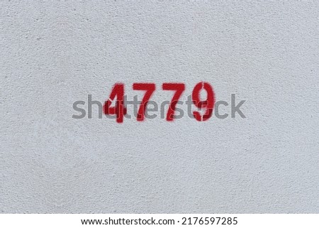 Red Number 4779 on the white wall. Spray paint.
