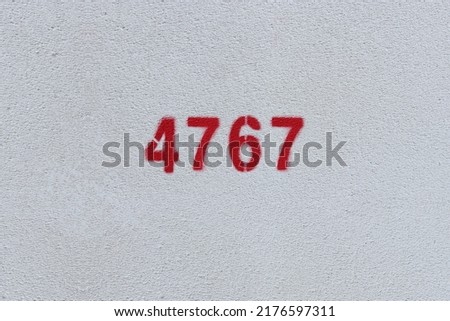 Red Number 4767 on the white wall. Spray paint.
