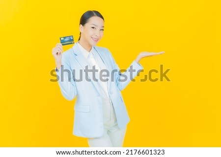 Portrait beautiful young asian woman smile with credit card on color background