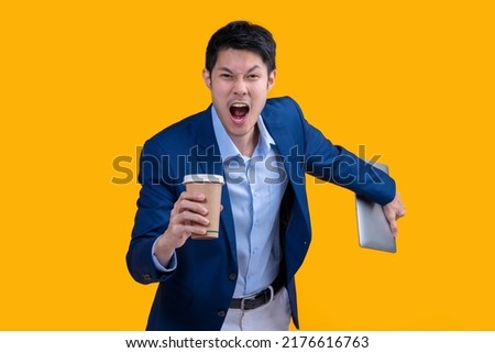 Successful complete Active Happiness asian cheerful exited young businessman running action while holding tablet and coffee mug in isolated on studio yellow colour background Royalty-Free Stock Photo #2176616763