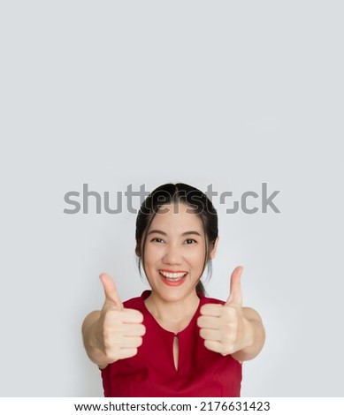 Asian beautiful woman make thumbs up hand sign gesture to encourage people with smile and happiness
