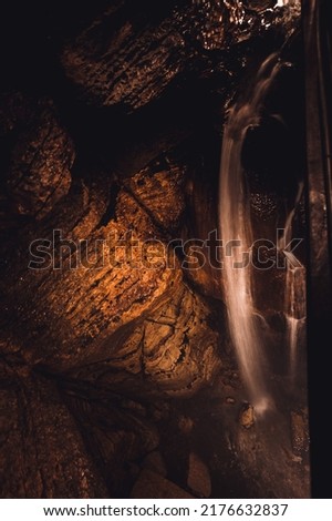 Flowing waterfall underground in Niagara Cave, MN Royalty-Free Stock Photo #2176632837