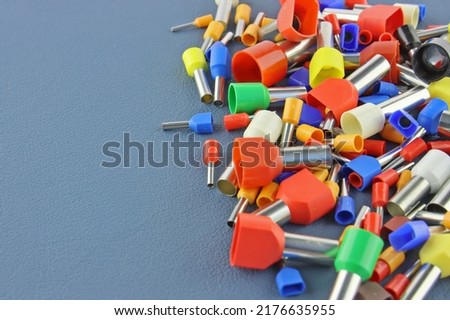 Coloured crimp terminals for different wire sizes. Copper sleeves for crimping electrical cables. Ferrules. Selective focus, copy space Royalty-Free Stock Photo #2176635955