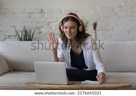 Woman make video call greets on-line tutor start distance class to gain new knowledge, improve foreign language skill, smile looks motivated. E-learn, tuition, virtual meeting event, education concept Royalty-Free Stock Photo #2176645021