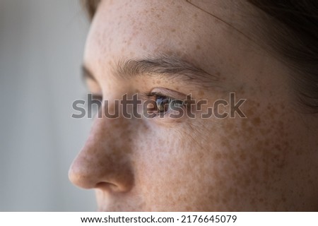 Side profile view face of freckled serious pensive woman staring aside. Close up cropped image of thoughtful young 18s female looking into distance. Concept of vision care, eyesight check up in clinic Royalty-Free Stock Photo #2176645079