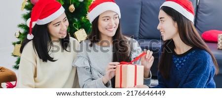 Asian beautiful woman holding gift boxes.Smiling face in room with Christmas tree decoration for holiday background.Christmas New year celebration party concept.