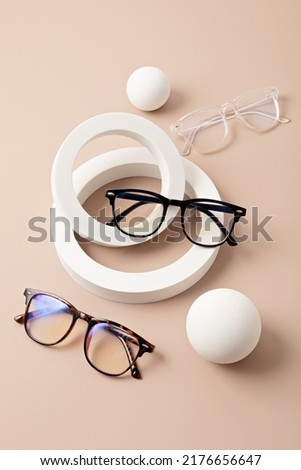 Stylish eyeglasses over pastel  background. Optical store, glasses selection, eye test, vision examination at optician, fashion accessories concept. Top view, flat lay Royalty-Free Stock Photo #2176656647