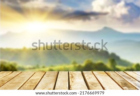 Wooden table top on blur mountain and grass field.Fresh and Relax concept.For montage product display or design key visual layout.View of copy space. Royalty-Free Stock Photo #2176669979