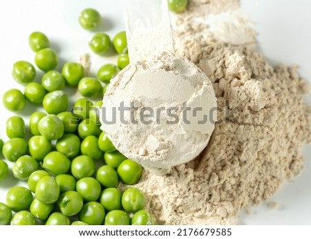 Plant base protein Pea Protein Powder in plastic scoop with fresh green Peas seeds on white Background, isolated copy space.  Royalty-Free Stock Photo #2176679585