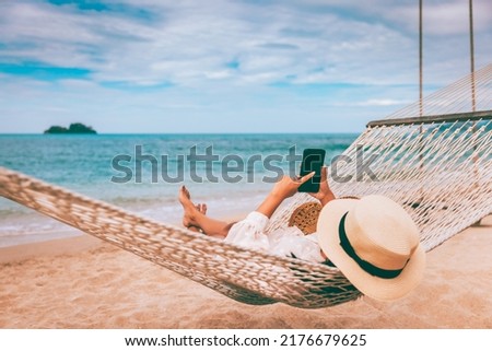 Summer travel vacation concept, Happy traveler asian woman using mobile phone and relax in hammock on beach in Koh Chang, Trad, Thailand Royalty-Free Stock Photo #2176679625