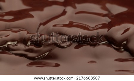 Melted chocolate in detail, floating on surface. Abstract sweet background.