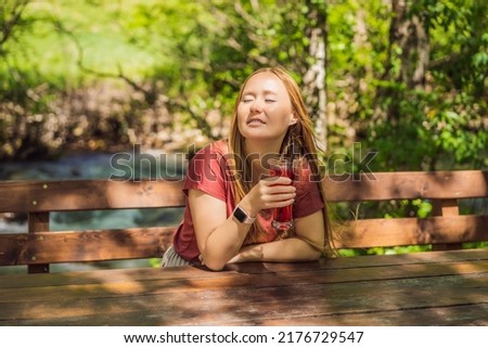 Woman drinking healthy fruits and vegetables juice smoothie in summer. Happy girl enjoying organic drink