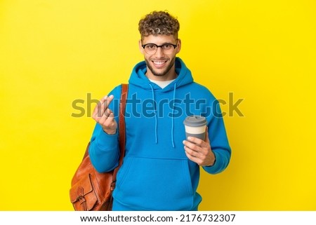 Young student blonde man isolated on yellow background making money gesture