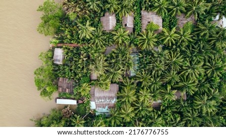 wide aerial top down view of tropical homestay along the Mekong river coastline of Ben Tre Vietnam