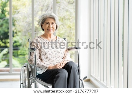 Happy elderly adult retired asian woman sit on wheelchair at home. Smiling asian senior old grandma sit on wheelchair at hospital Royalty-Free Stock Photo #2176777907