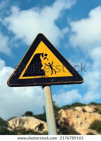 Сareful, cliff break Warning Triangular Sign. Triangular attention sign Break Stones. Warning Break Sign over a blue sky