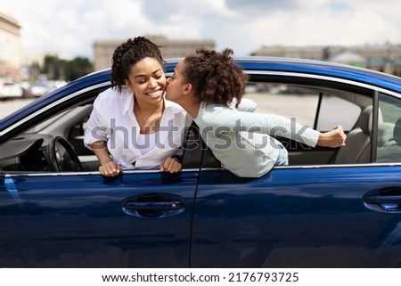 Auto Ownership. Happy African American Daughter Kissing Mother Posing In New Car In Urban Area. Mom And Kid Girl Buying Vehicle Together. Automobile Leasing Concept