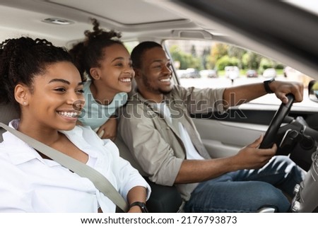 Side View Of Cheerful Family Driving A Car Having Road Trip. Parents And Daughter Sitting In Automobile Seats Smiling Looking Aside. Auto Leasing And Purchase. Selective Focus Royalty-Free Stock Photo #2176793873