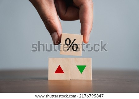 businessman holding a wooden block with percentage and up or down arrow Mortgage and Loan Rates Interest rates, stocks, ratings, interest rate ideas are falling or vice versa.