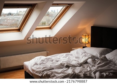 Scandinavian style bedroom with white bed and skylights Royalty-Free Stock Photo #2176798887