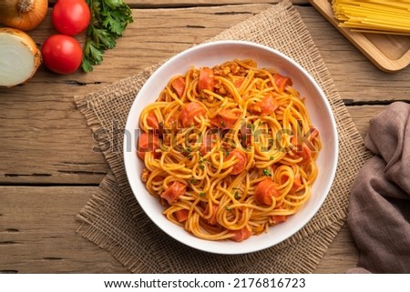 Hot dog or sausage stuffed with spaghetti in tomato pork sauce in white plate.Top view Royalty-Free Stock Photo #2176816723