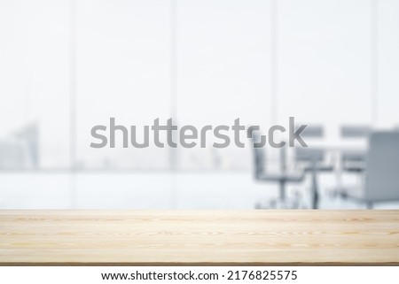 Empty office wooden desktop with empty space on modern boardroom with large window background, closeup, mock up Royalty-Free Stock Photo #2176825575