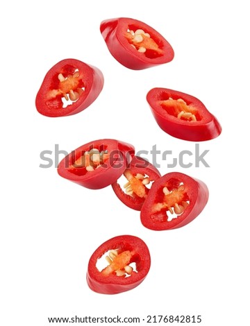 Falling sliced red hot chili peppers isolated on white background, clipping path Royalty-Free Stock Photo #2176842815