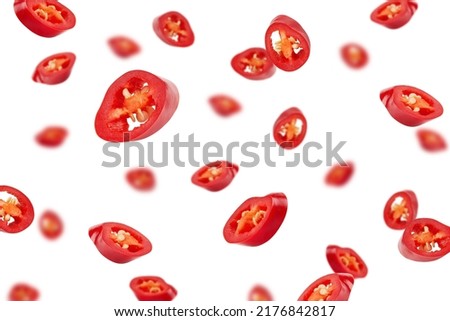 Falling sliced red hot chili peppers isolated on white background, selective focus Royalty-Free Stock Photo #2176842817