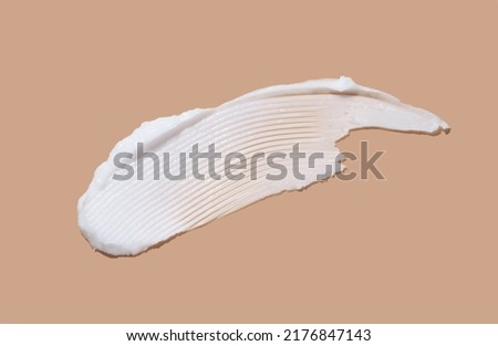White cosmetic cream lotion swatch smear smudge on brown color background.  Royalty-Free Stock Photo #2176847143