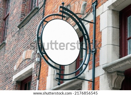 Circle mockup of street signboard on old brick wall, blank signage to add company or restaurant logo