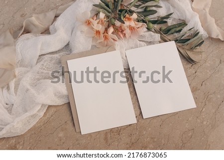 Summer Mediterranean floral wedding stationery. Set of greeting cards, invitations mock ups. Beige marble background. Oleander flowers, live tree branches. Ribbons, white muslin table runner. Top view