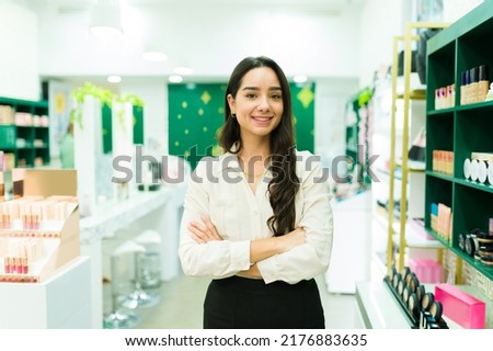 Portrait of a gorgeous woman and salesperson feeling happy while working at the makeup shop  Royalty-Free Stock Photo #2176883635