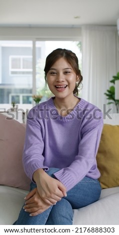 Young influencer vlogger teen girl asia people sit easy relax at cozy sofa home selfie vlog live talk share chat on social media app screen reel   Model lady video call look at camera Royalty-Free Stock Photo #2176888303