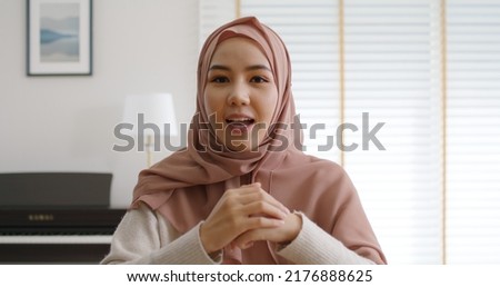 Young Gen Z workforce islam woman look at webcam camera video call talk work at home office. Asia people arab hijab scarf girl smile study relax remote learn online share job idea on digital webinar. Royalty-Free Stock Photo #2176888625