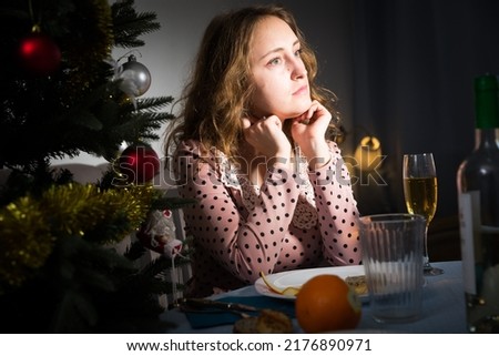 Sad woman is bored with champagne in New Year night. High quality photo
